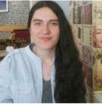 Resimde uzun, siyah saçlı, gözleri kapalı ve yüzünde geniş, içten bir gülümseme olan bir kadın görülüyor. Sırtını dik tutmuş, kolları iki yanında, saçları omuzlarından ve sırtından aşağı dökülüyor. Yirmili yaşlarında görünüyor ve ten rengini tamamlayan beyaz bir bluz giyiyor. Memnun ve neşeli görünüyor, bir güven ve duruş havası yayıyor. İfadesi ve duruşu huzur ve dinginlik hissi veriyor. Uzun saçları güzelliğine ve kadınsılığına katkıda bulunarak mutlu ve kaygısız bir kadın resmini tamamlıyor.