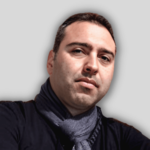 Bu, selfie çeken genç bir adamın görüntüsüdür. Kollarını açmış, açık renkli bir duvarın önünde durmaktadır. Beyaz bir tişört, mavi kot pantolon ve bir çift spor ayakkabı giymektedir. Sağ elinde bir cep telefonu var ve kendi fotoğrafını çekmek için telefonu havaya kaldırıyor. Yüzünde parlak bir gülümseme var ve gözleri konsantrasyonla kapalı. Koyu renk saçları düzgünce bir tarafa taranmış. Hayatının bir anını yakalarken rahat ve mutlu görünüyor.