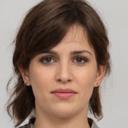 A woman is seen in close-up, her face illuminated by the light of the sun. She has bright blue eyes, framed by long, dark eyelashes. Her lips are slightly parted, her skin smooth and glowing. Her dark hair is pulled back, giving her a serious yet peaceful expression. She looks off with a thoughtful gaze, her chin slightly raised, and her hands clasped in her lap. Her posture is poised and graceful, her presence both powerful and gentle. She is a picture of beauty and strength, a moment of peace among the chaos of life.